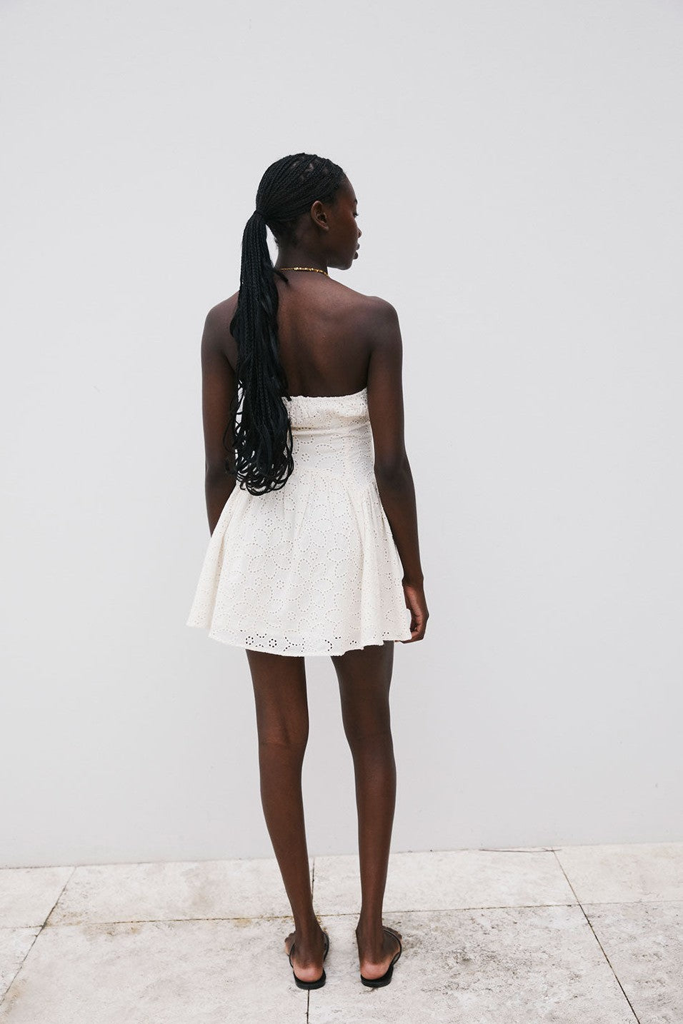Beige mini dress with a strapless neckline, styled on model