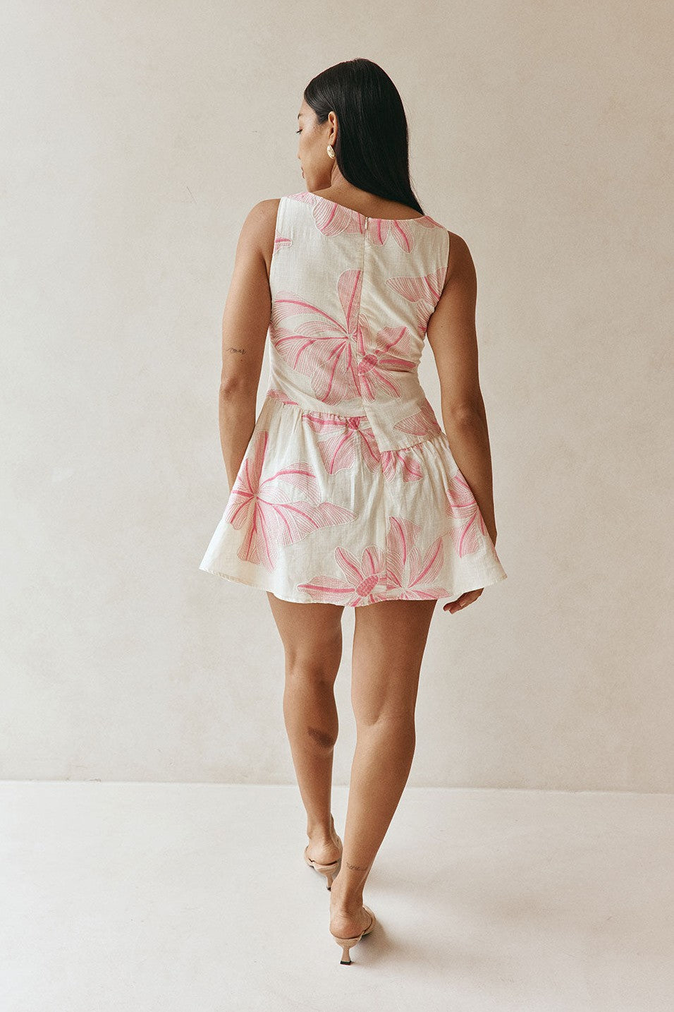 Pink mini dress with a wrap silhouette, back view