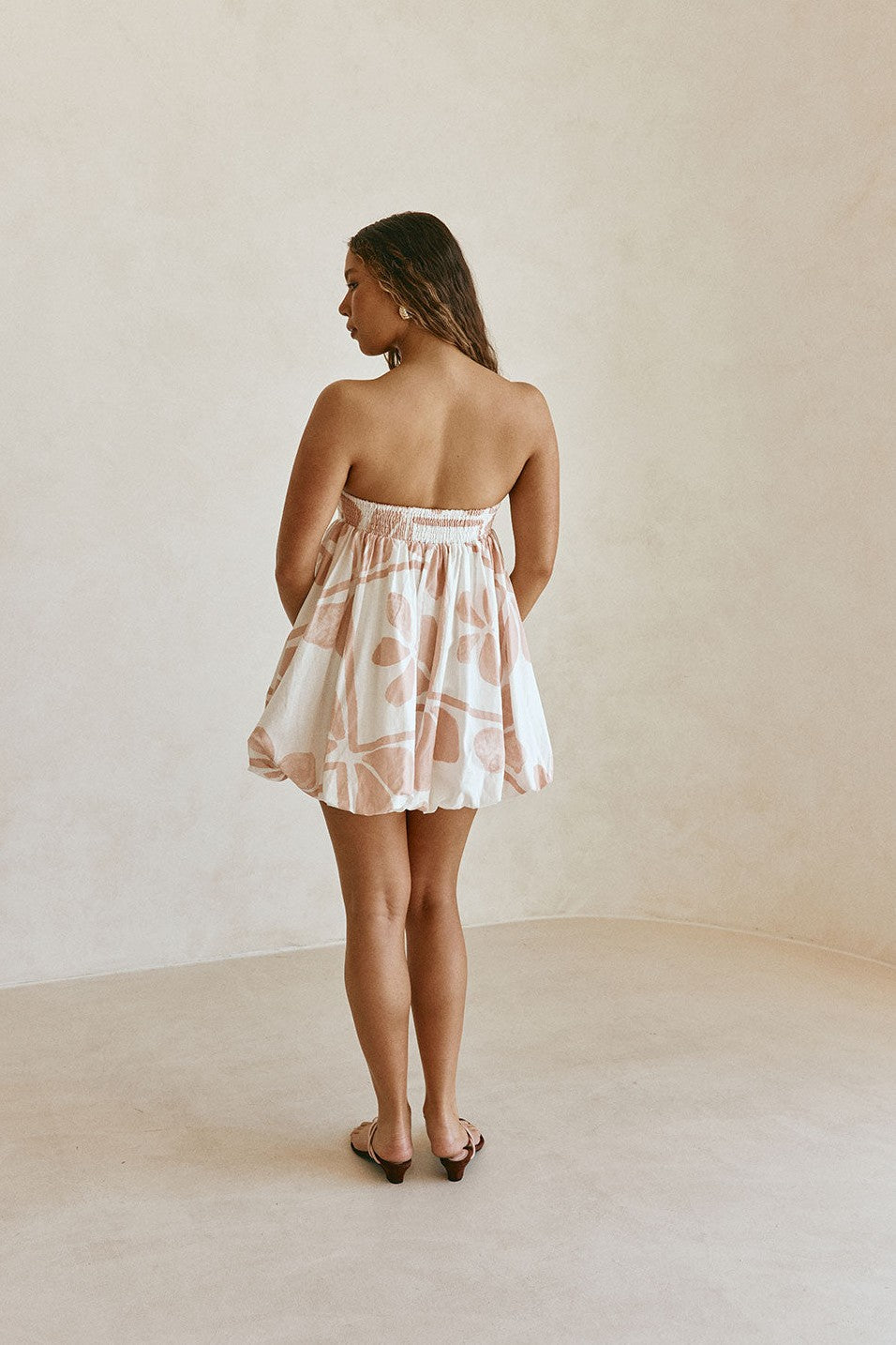 Pink mini dress with a strapless neckline, back view