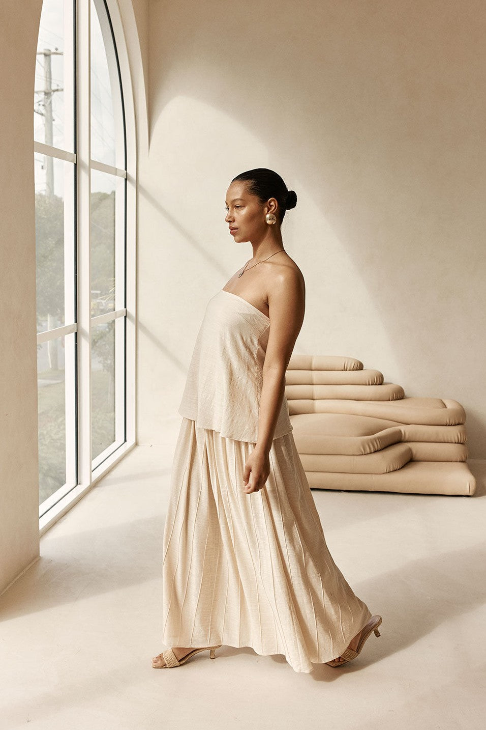 Beige maxi dress with a strapless neckline, styled on model